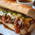 “A rustic wooden board holding a freshly toasted French Dip Sandwich roll stuffed with tender, shredded roast beef and melted provolone, flecked with chopped fresh thyme, served alongside golden-brown hand-cut fries and a small white ramekin of dark, aromatic au jus in soft daylight.”