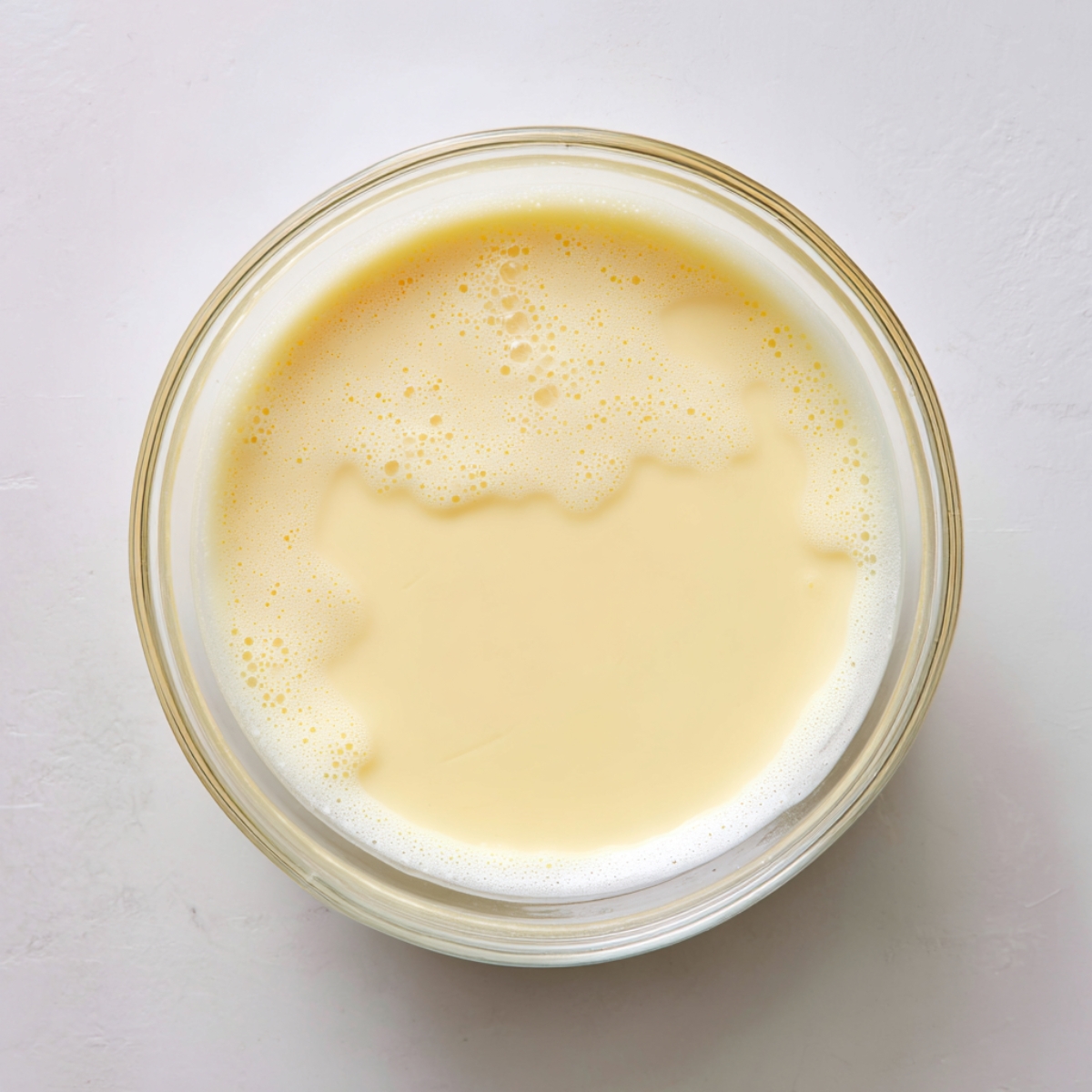 Flour, sugar, salt, and active dry yeast mounded separately in one glass bowl.