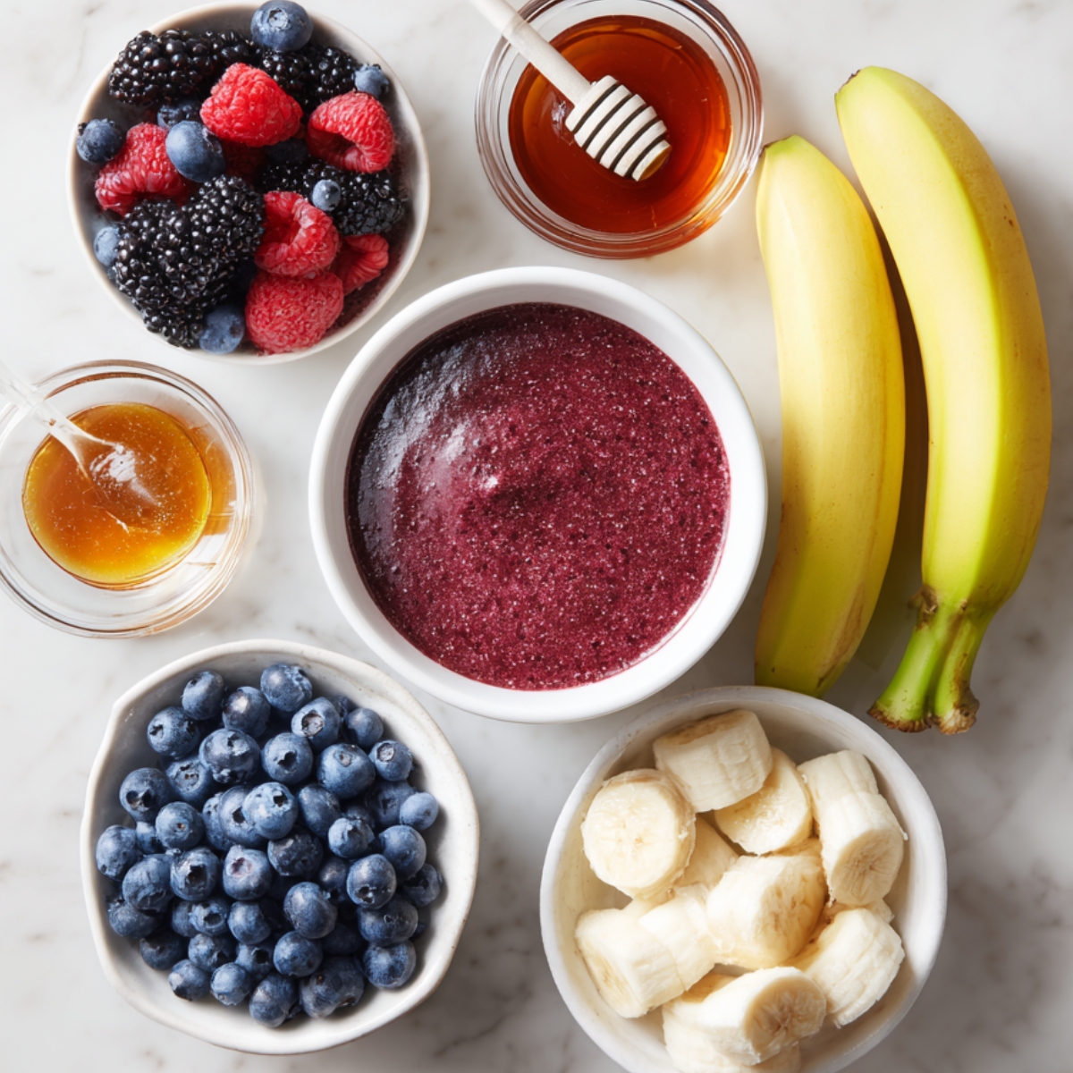 An assortment of acai bowl toppings, including chopped nuts, shredded coconut, strawberries, blueberries, and other fresh fruits arranged in small bowls.