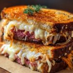 The finished Reuben Sandwich hot off the skillet: crispy golden bread with a buttery crunch, gooey Swiss cheese melting into savory beef and sauerkraut, ready to bite into.