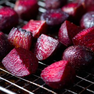 Roasted beet chunks cooling on a wire rack, glistening with a caramelized surface.