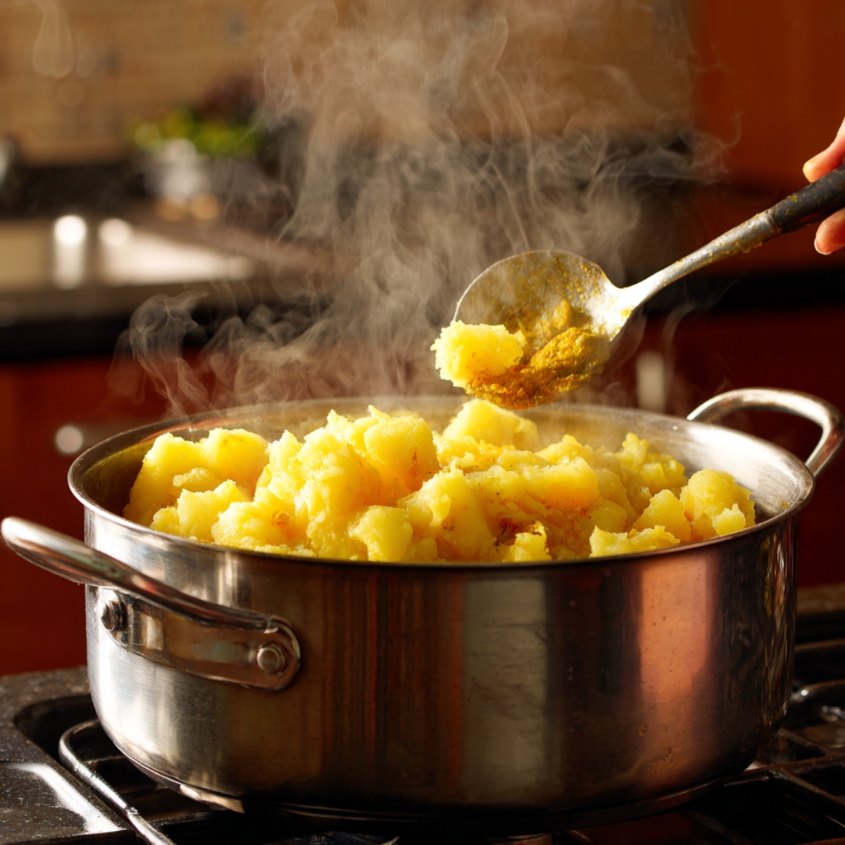 A bowl of gram flour batter mixed with spices and water, thick and yellow in texture.