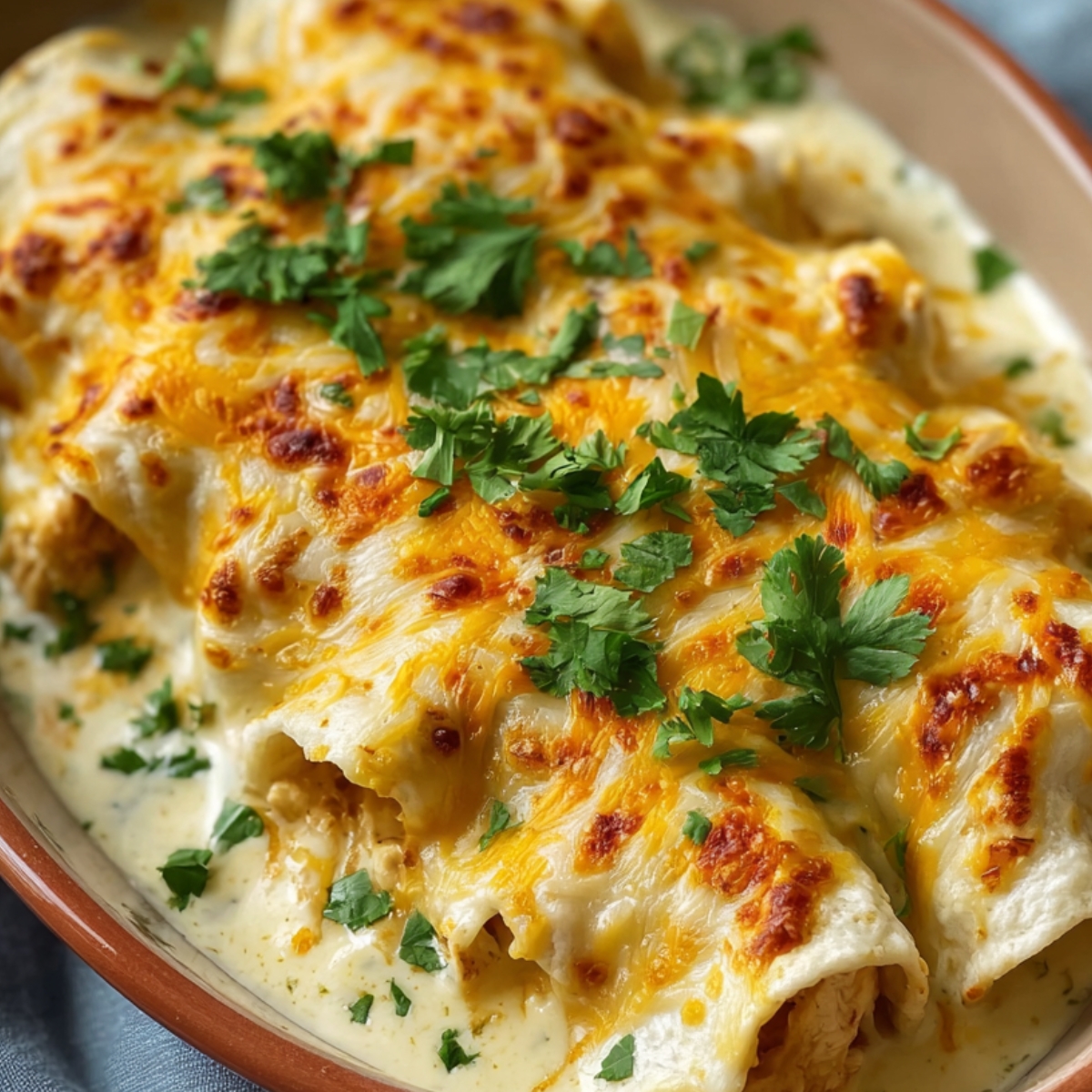 Best Creamy White Chicken Enchiladas Recipe 9 Ingredients on a wooden surface including cooked seasoned chicken, cheeses, green onions, herbs, and sour Creamy White Chicken Enchiladas.