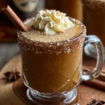 A recipe card for hot buttered rum recipe , showing ingredients like dark rum, butter, spices, and sugar, and instructions on how to prepare the drink.