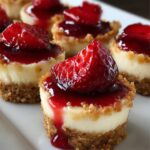 Mini Strawberry Cheesecake Bites : Small cheesecake bites with a graham cracker crust, topped with glossy strawberry sauce and fresh strawberry pieces.