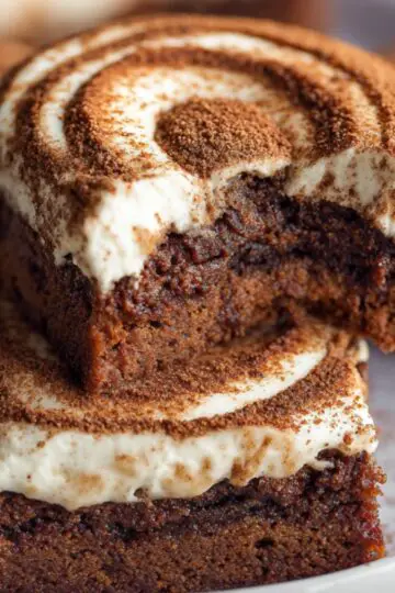 Tiramisu cookies with mascarpone cream swirls and cocoa dusting served on a white plate.