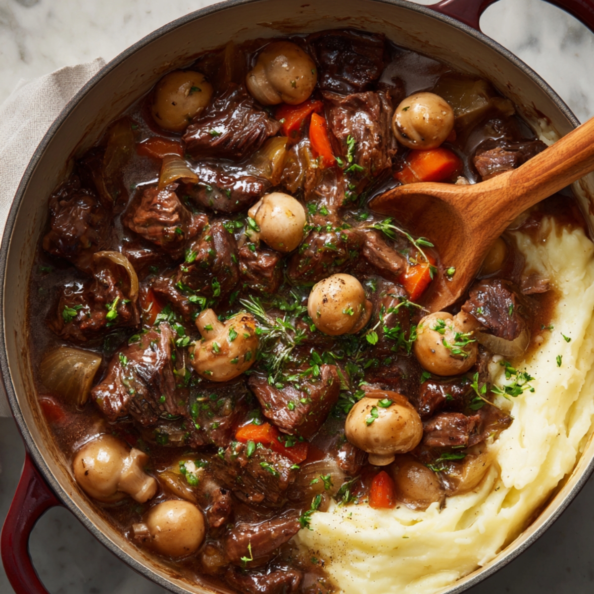 Once the braising is nearly done, serve the Beef with mashed potatoes and garnish with fresh herbs.