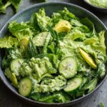 A bowl of fresh Green Goddess Salad Recipe made with lettuce, cucumber, avocado, and herbs, all tossed in a creamy green dressing
