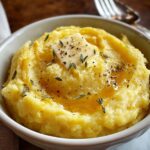 Mashed Potato Squash A small bowl of mashed potato squash topped with a pat of butter, chopped chives, and black pepper.