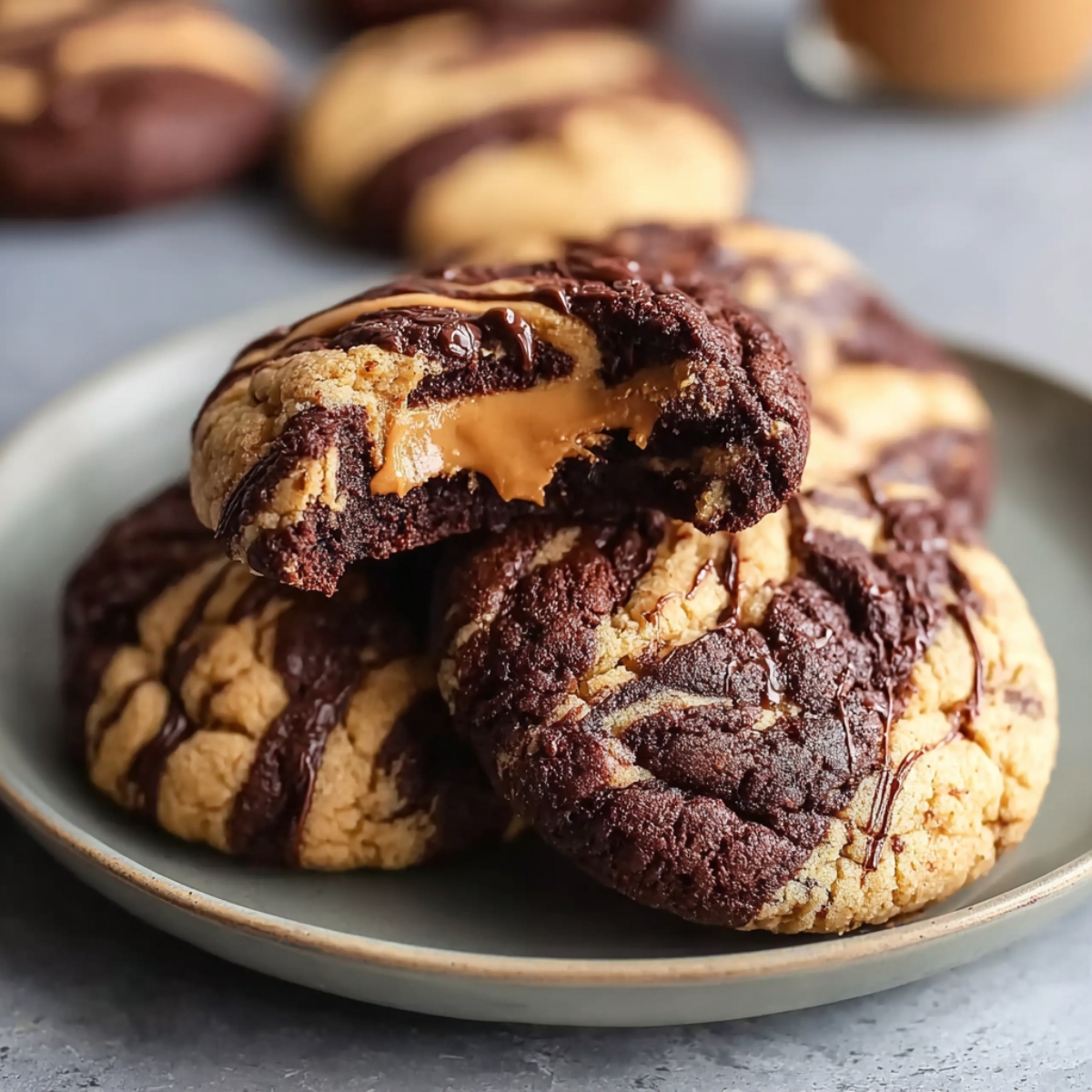The Best Peanut Butter Brownie Swirl Cookies Recipe 13 A chocolate-and-peanut-butter swirl cookie broken open to reveal a gooey caramel-like peanut-butter center. The cookie has a soft, marbled texture.