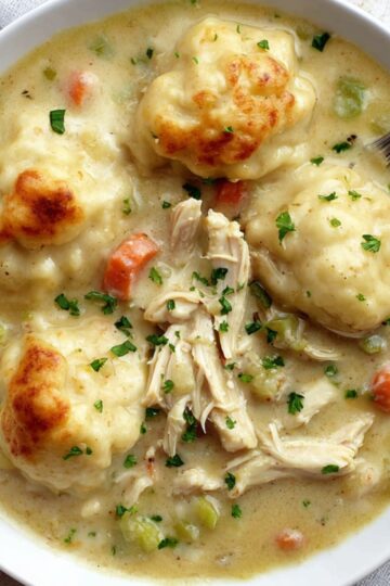 Bisquick Chicken And Dumplings A bowl of creamy Bisquick chicken and dumplings featuring tender shredded chicken, soft vegetables, and fluffy golden dumplings garnished with fresh parsley.