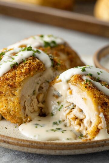 Healthy Chicken Pillows Recipe | Ready in 30 Minutes 2 Chicken Pillows Golden baked chicken pillow cut open and topped with creamy gravy, showing the rich chicken filling inside.