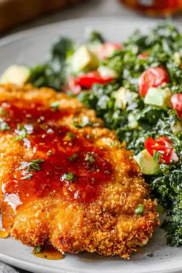 Healthy Hot Honey Chicken Recipe In 30 Minutes 21 Hot Honey Chicken Crispy breaded chicken cutlet drizzled with hot honey, served on a plate alongside a chopped kale salad with cherry tomatoes and avocado.