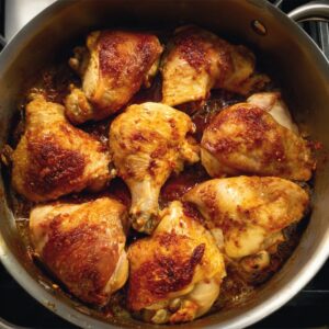 Easy Chicken Paprikash Recipe | Traditional Hungarian 17 Golden-brown chicken pieces arranged in a pot before simmering, seasoned with paprika and ready to be cooked in sauce