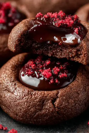 Chocolate Cherry Cookies Recipe | Fudgy & Easy to Make 23 Chocolate Cherry Cookies Bitten chocolate thumbprint cookie with melted chocolate center and red topping, cherries in the background.