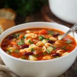 Minestrone Soup Bowl of homemade minestrone soup with pasta, beans, vegetables, and fresh parsley, ready to serve.