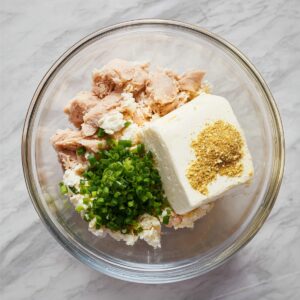 Healthy Chicken Pillows Recipe | Ready in 30 Minutes 16 Mixing bowl filled with shredded chicken, cream cheese, green onions, and seasoning before stirring.