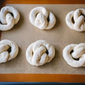 Easy Cinnamon Sugar Soft Pretzels | Homemade Recipe 16 “Raw pretzel dough shaped into knots, arranged on a silicone baking mat before baking.”
