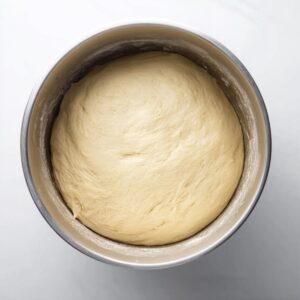 Easy Cinnamon Sugar Soft Pretzels | Homemade Recipe 15 “Top-down view of smooth risen dough resting in a metal mixing bowl, ready for baking.