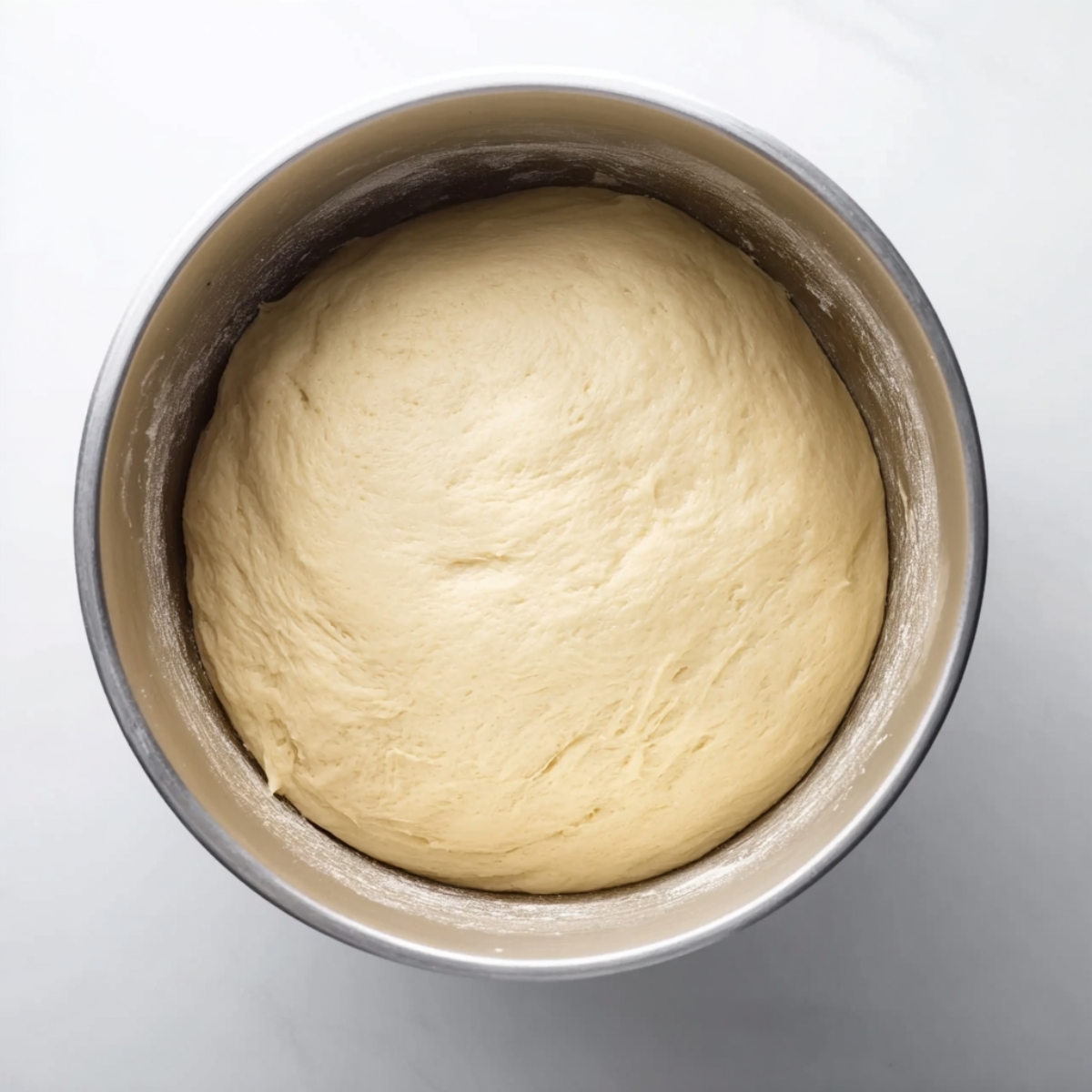 Easy Cinnamon Sugar Soft Pretzels | Homemade Recipe 10 “Top-down view of smooth risen dough resting in a metal mixing bowl, ready for baking.