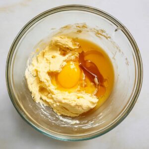 Easy Honey Cookies Recipe - Chewy, Spiced & Foolproof 17 A glass bowl containing softened butter, eggs, and vanilla extract for mixing into honey cookie dough.