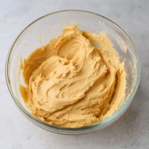 Easy Honey Cookies Recipe - Chewy, Spiced & Foolproof 18 A glass bowl filled with a smooth honey cookie dough mixture, ready to be shaped and baked.