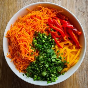 Easy Korean Carrot Salad Recipe 16 Julienned carrots, sliced bell peppers, chopped green onions, and cilantro prepared for Korean carrot salad