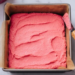 Strawberry Brownies Recipe | Soft, Pink & Ready in 30 Min 17 Strawberry brownie batter spread evenly in a square baking pan lined with parchment paper before baking.