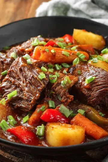 Easy Beef Mechado Recipe - Tender Filipino Tomato Beef Stew 6 Beef Mechado Finished beef mechado served in a black bowl with tender beef, potatoes, carrots, and bell peppers in rich sauce.