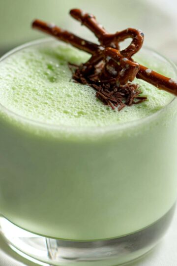 Grasshopper drink A creamy pale green grasshopper drink served in a short glass, topped with foam and garnished with a chocolate-covered pretzel stick.