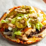 Smash Burger Tacos A finished smash burger taco with cheese, pickles, shredded lettuce, and sauce, all assembled on flatbread, ready to be eaten.