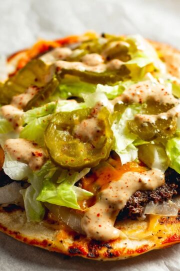 Smash Burger Tacos Recipe | Crispy & Easy in Minutes 18 Smash Burger Tacos A finished smash burger taco with cheese, pickles, shredded lettuce, and sauce, all assembled on flatbread, ready to be eaten.