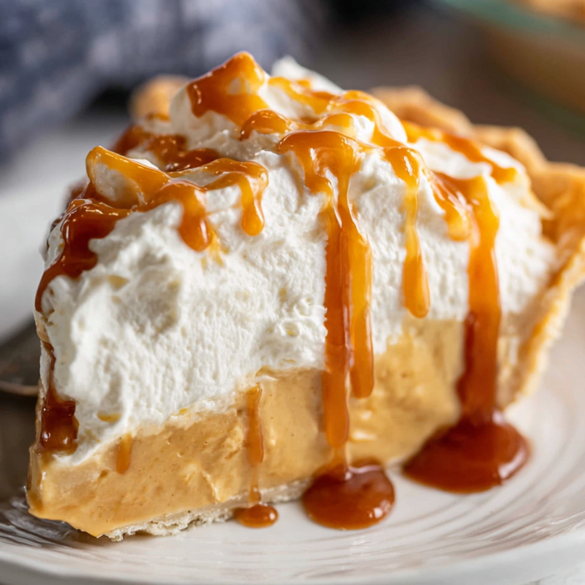 butterscotch pie Slice of butterscotch cream pie with a flaky crust, creamy caramel filling, and whipped cream topping drizzled with sauce.