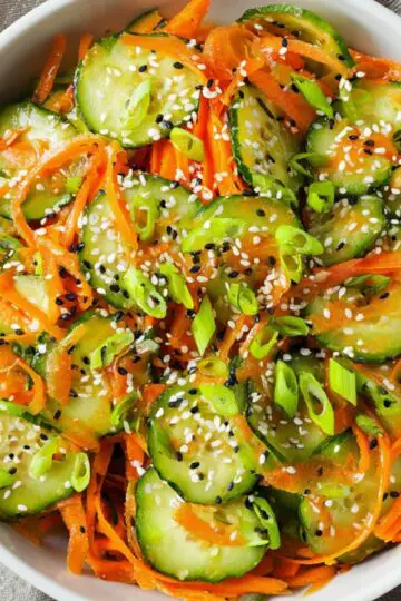 Healthy Cucumber and Carrot Salad Recipe 7 cucumber and carrot salad Fresh cucumber and carrot salad with sliced green onions and sesame seeds, served in a white bowl, showcasing vibrant colors and textures, perfect for a healthy and refreshing dish.