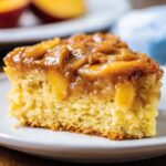 fresh fruit tart Side view of a slice of brown sugar peach cake showing tender crumb and juicy peaches under a glossy brown sugar topping.