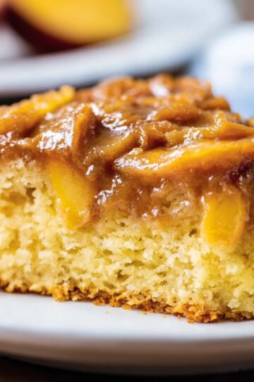 Brown Sugar Peach Cake Recipe | Easy & Moist 2 fresh fruit tart Side view of a slice of brown sugar peach cake showing tender crumb and juicy peaches under a glossy brown sugar topping.