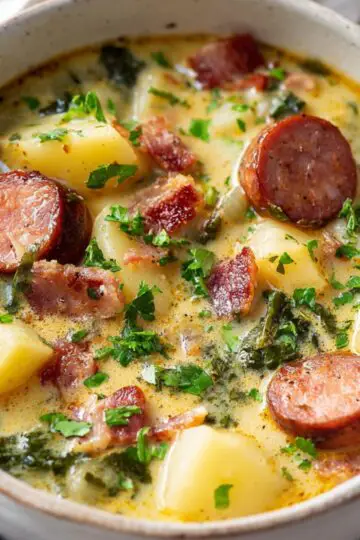 Easy Kielbasa Potato Soup | One Pot Comfort Food 20 kielbasa potato soup served in a ceramic bowl, creamy texture, sausage slices, tender potatoes, fresh herbs, cozy comfort meal, minimal styling, Pinterest-style food photography, bright natural light