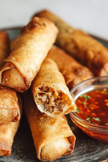 Crispy Lumpia Recipe | Easy Filipino Spring Rolls 3 lumpia recipe Close-up of freshly fried lumpia spring rolls showing the savory filling, served with sweet chili sauce on a ceramic plate