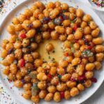 struffoli recipe italian Finished Italian struffoli dessert arranged in a ring shape, coated in honey and decorated with colorful sprinkles and candied fruit.