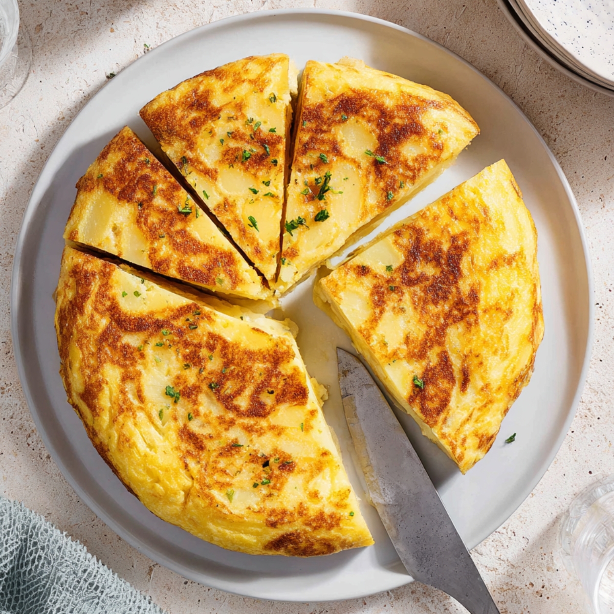Spanish Tortilla Recipe - Easy 5-Ingredient Authentic 13 Overhead shot of a classic Spanish tortilla cut into wedges on a white plate, golden potato omelette, natural sunlight, Mediterranean food photography, clean neutral background