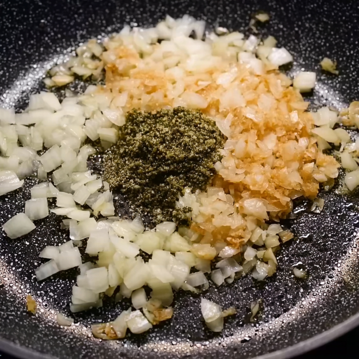 Creamy Tomato Gnocchi Recipe | Ready in 16 Minutes 10 Chopped onions sautéing in a pan with garlic and pesto added in the center.