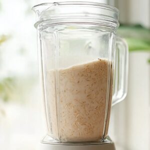 Authentic Horchata Recipe | Homemade Mexican Drink 17 Bright, airy kitchen scene with a blender filled with freshly blended horchata, creamy off-white rice milk with visible rice particles, soft natural window light, minimal modern kitchen background, fresh and clean food photography style, high resolution, realistic, lifestyle food aesthetic.