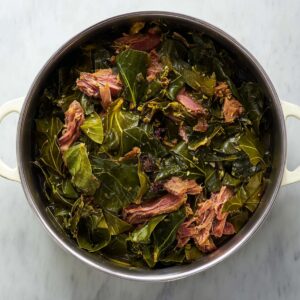 Best Turnip Greens Recipe - Smoked Turkey & Pot Liquor 18 Cooked collard greens with shredded smoked ham hock inside a large pot after slow simmering.