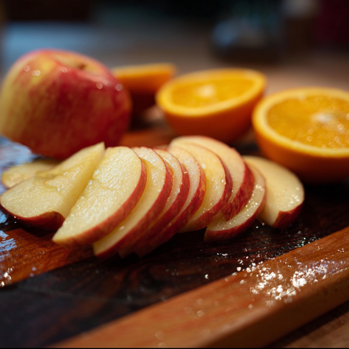 Easy 6-Ingredient Wassail Recipe | Holiday Spiced Cider 10 Sliced apples and oranges on a wooden cutting board, prepared for making homemade wassail.
