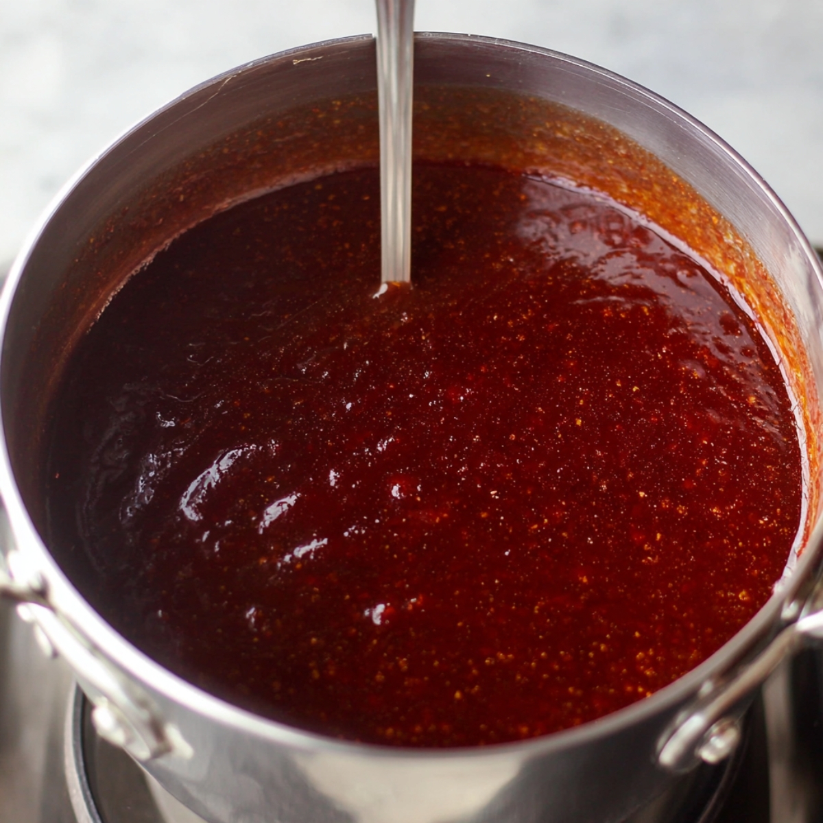 Healthy Baked Ham Recipe 11 A shiny, vibrant sauce in a pan, ready to be poured over the baked ham.
