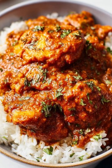 Best Achiote Chicken Recipe 3 Achiote Chicken A bowl of tender chicken cooked in achiote sauce, served over a bed of fluffy white rice, garnished with fresh herbs