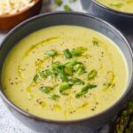 Asparagus Soup A creamy and vibrant bowl of asparagus soup, garnished with freshly chopped green onions and a drizzle of olive oil, offering a smooth and rich texture, perfect for a comforting meal.