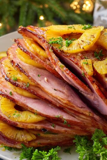 Healthy Baked Ham Recipe 2 Baked Ham A beautifully sliced baked ham with pineapple slices arranged between the layers, garnished with parsley.