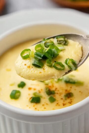 Healthy Chinese Steamed Eggs Recipe 3 Chinese Steamed Eggs A spoonful of the steamed eggs, garnished with some green onions, showing the smooth texture of the dish.