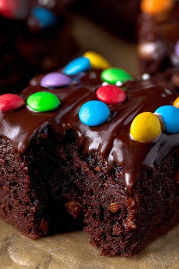 Easy Cosmic Brownies Recipe 4 Cosmic Brownies Recipe A fresh batch of brownies topped with shiny chocolate ganache and colorful candy-coated chocolates.